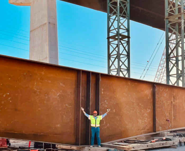A man stands in a construction area where highway bridgework is occurring.