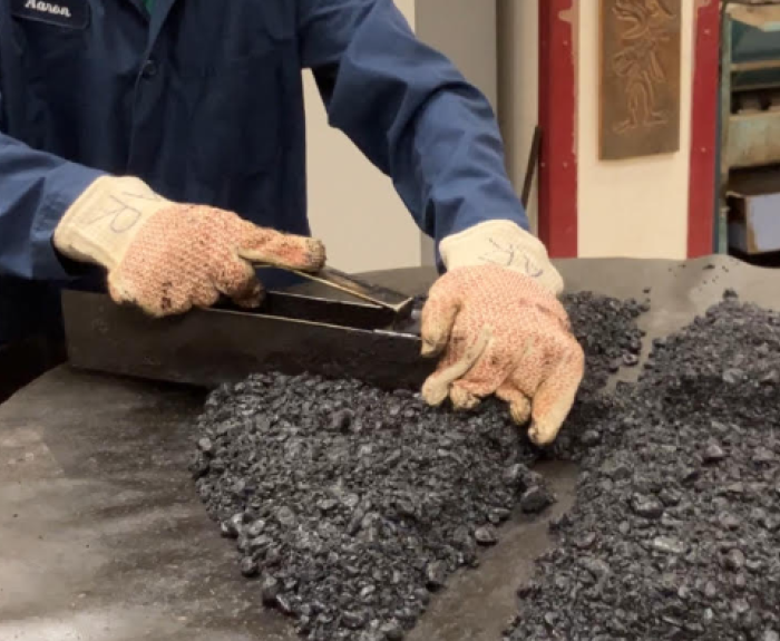 A lab worker takes samples of asphalt.