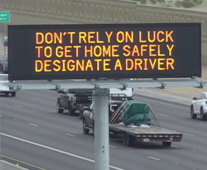 A digital message board on the highway encourages motorists to designate a driver.