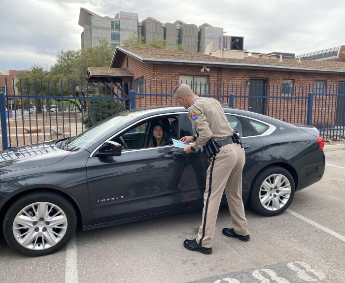 A motorist handing a blue envelope to a DPS trooper during a demonstration of the program.