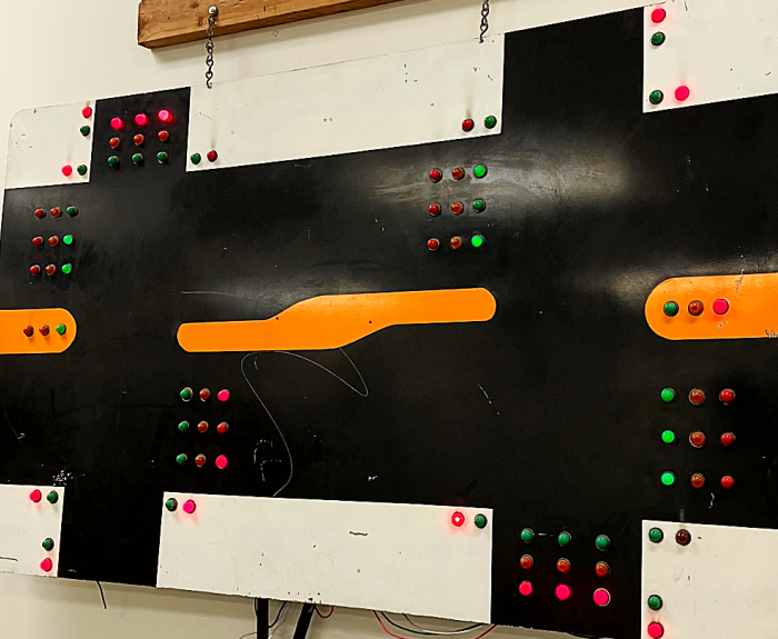 A signal devide used for timing traffic signals and other training purposes hangs on a wall.
