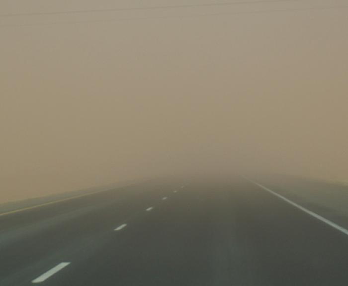 A wall of dust falling onto a highway.
