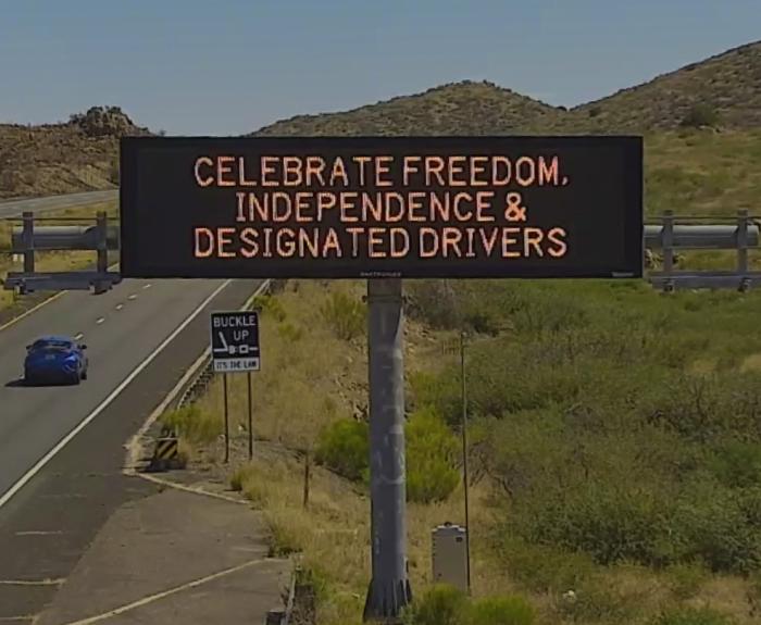 An electronic message board near a highway displays the message, "celebrate freedom, independence and designated drivers."