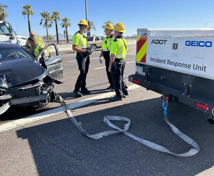 Workers at the scene of a car crash on the highway