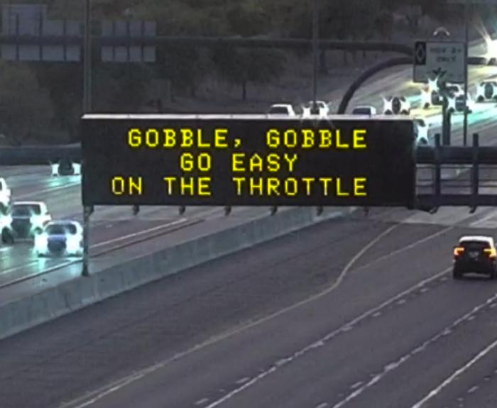 A digital message board on the highway encourages motorists to slow down.