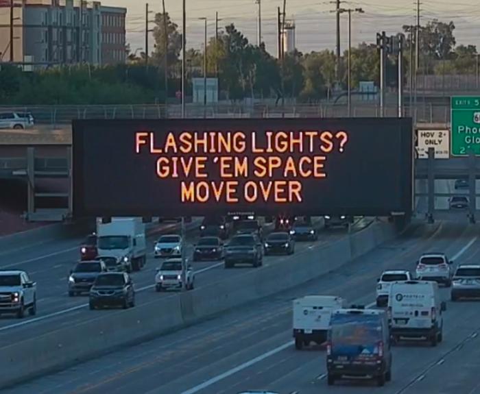 A digital message board on the highway encourages motorists to move over.