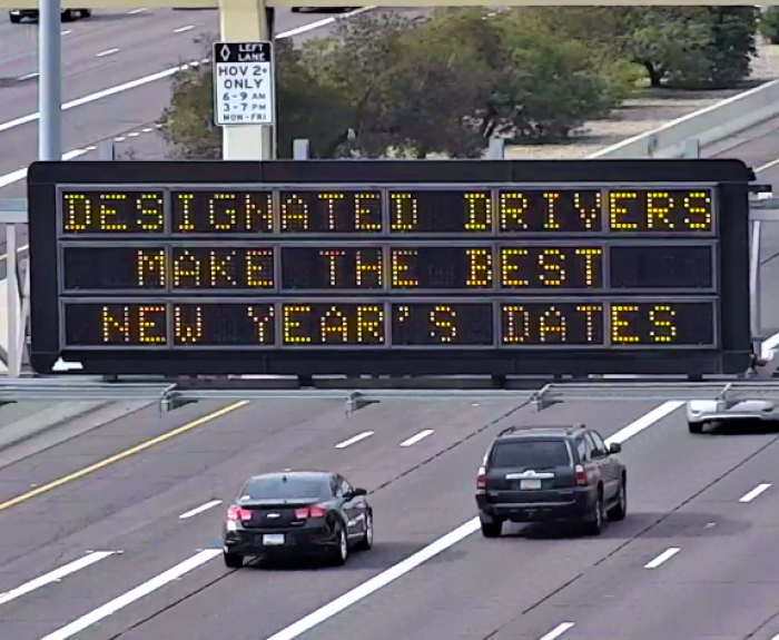 A digital message board on the highway encourages motorists to designate a driver.