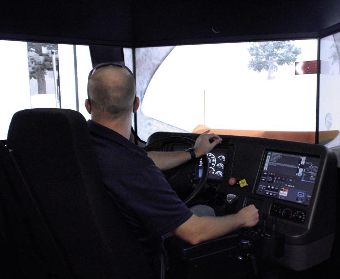 A man operating a snowplow simulator