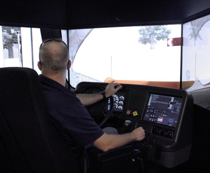 An employee operating a snowplow simulator