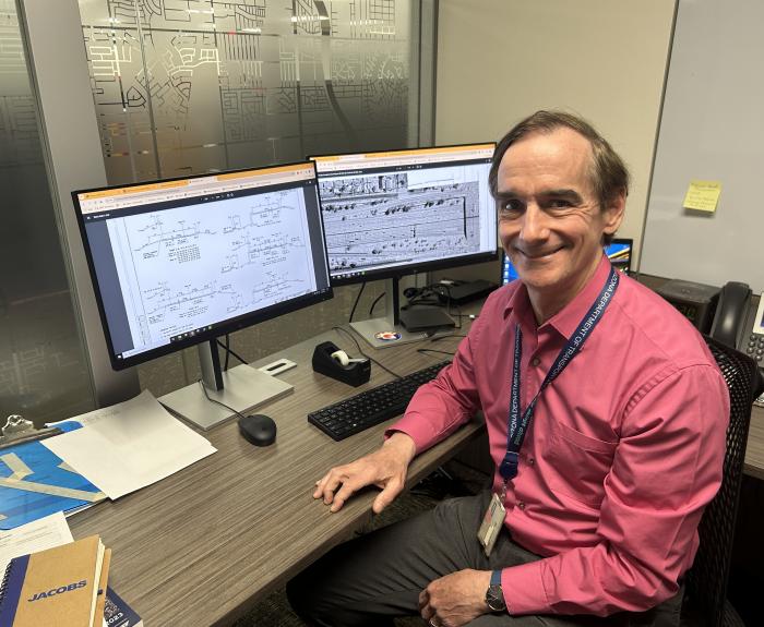A man sitting in front of computer monitors