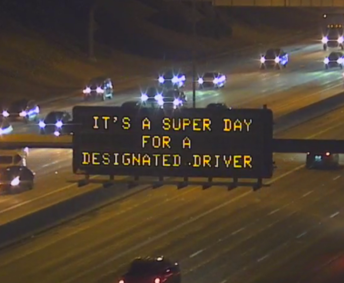 A digital message board on the highway encourages motorists to designate a driver.