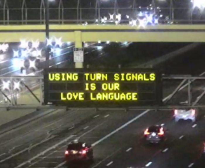 A digital message board on the highway encourages motorists to use their blinker.