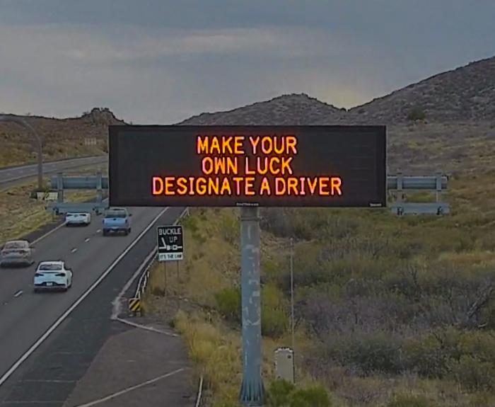 A digital message board on the highway encourages motorists to designate a driver.