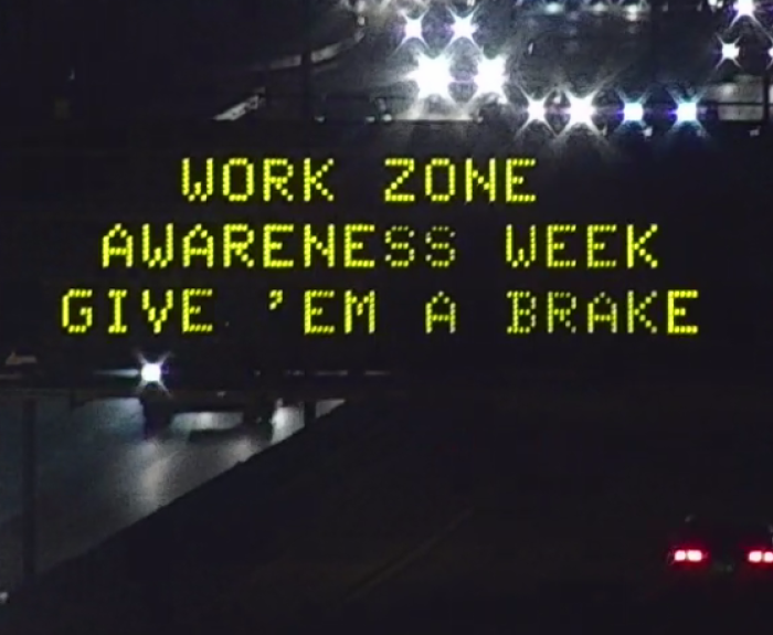 A digital message board on the highway encourages motorists to slow down.