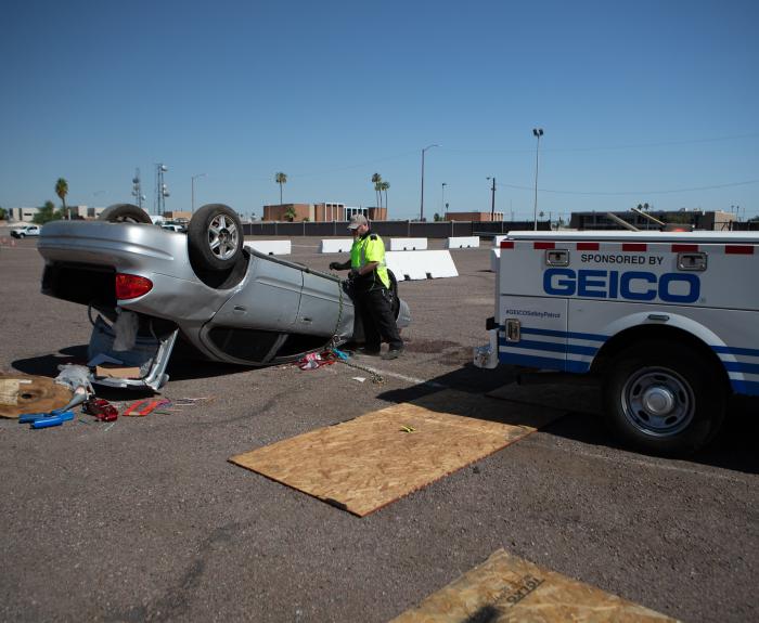 An ADOT truck pulling an overturned vehicle in a parking lot.