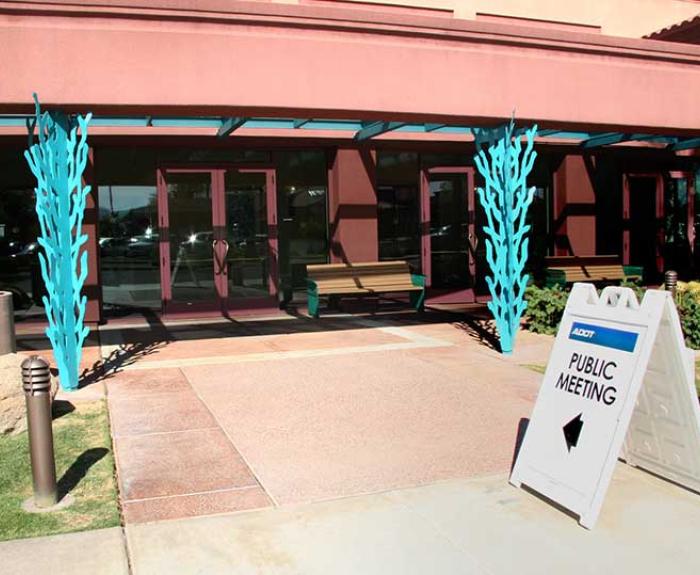 Public Meeting sign in front of building entrance