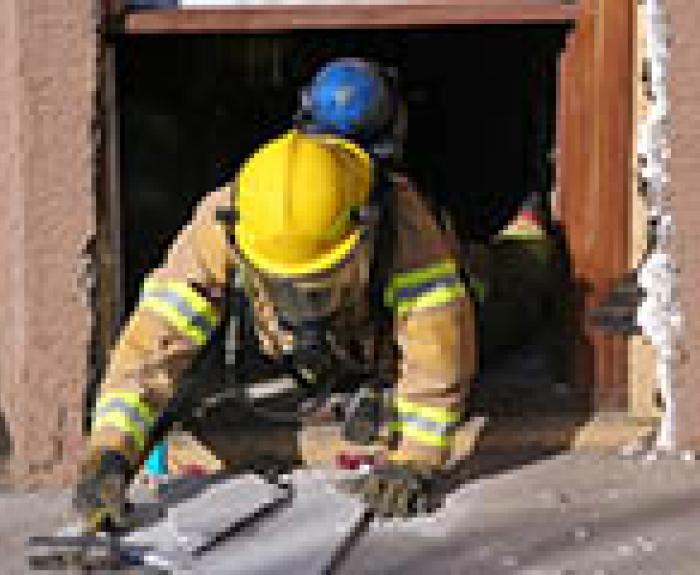 Firefighter crawling out of building during training