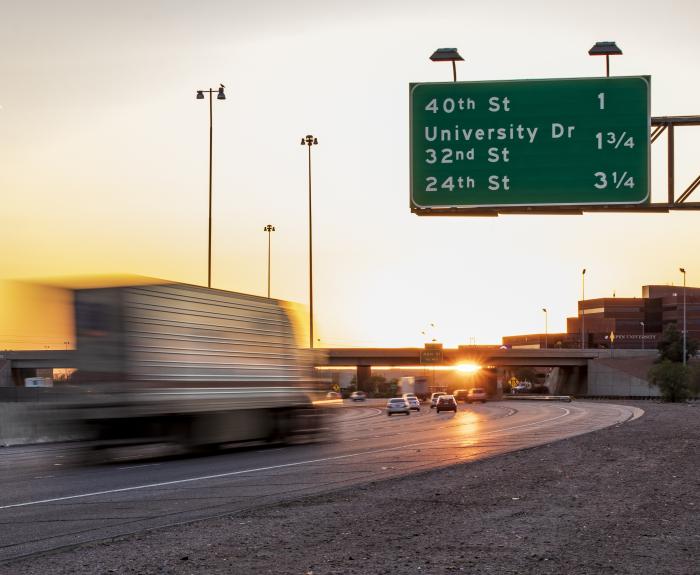 Semi-truck on highway at sunset