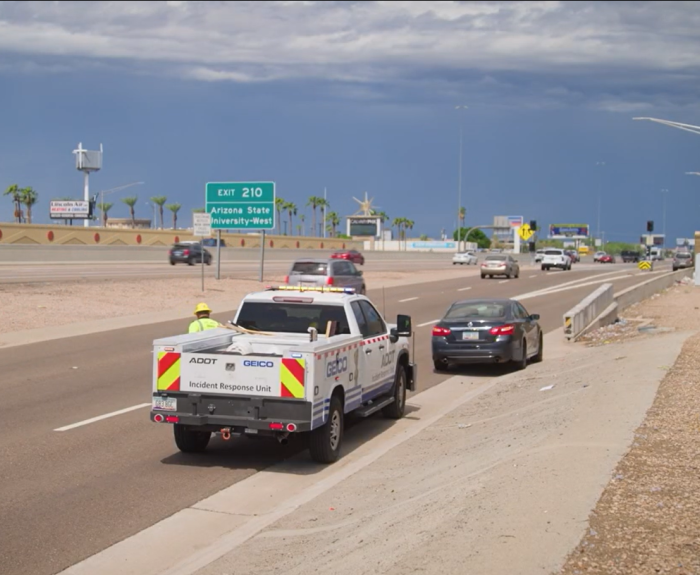 An ADOT truck assisting a stranded motorist on the side of the highway