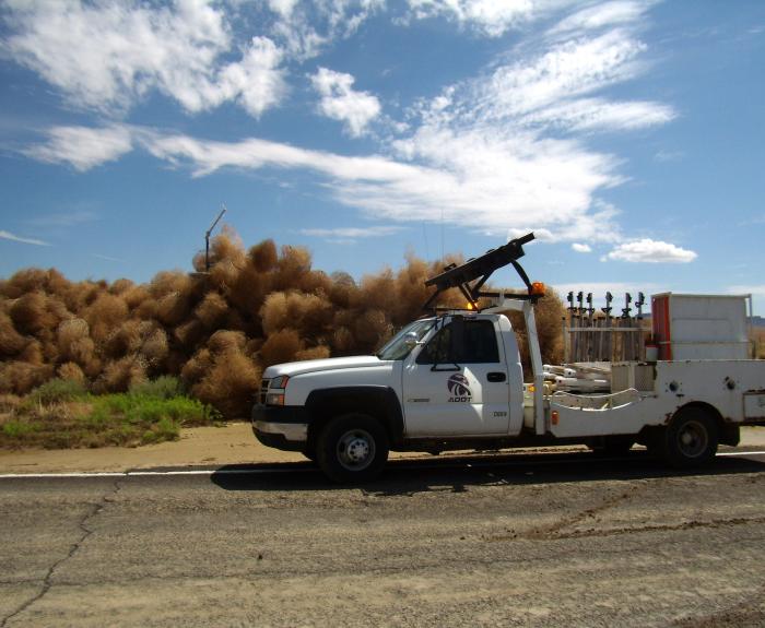 Tumbleweeds along a highway with an ADOT truck in foreground