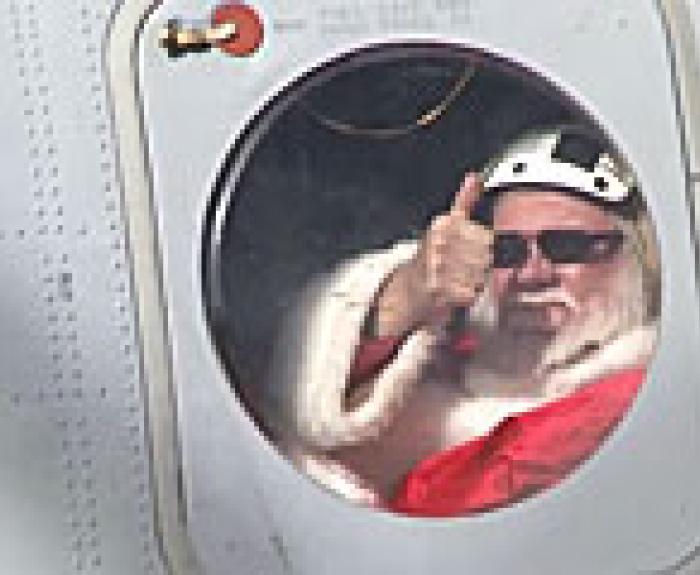 Santa giving thumbs up through helicopter window