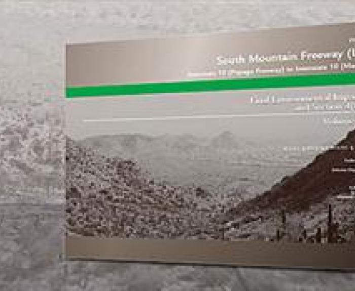 A display board with the title South Mountain Freeway (Loop 202) and information about an environmental impact statement, set against a grayscale mountain landscape background.