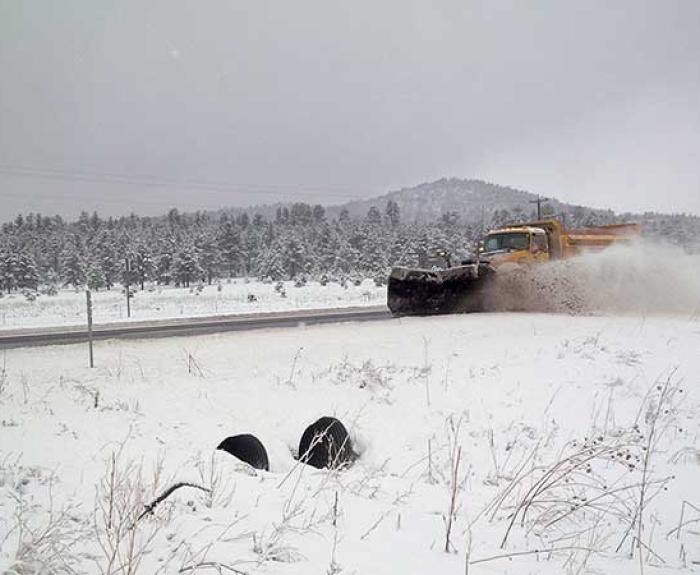 Tow plow clears snow from a highway