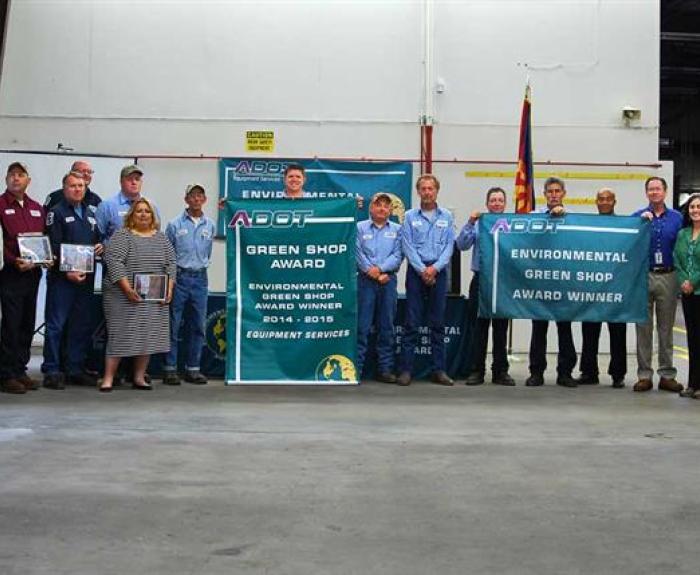 Group of ADOT workers holding banners for green shop award.