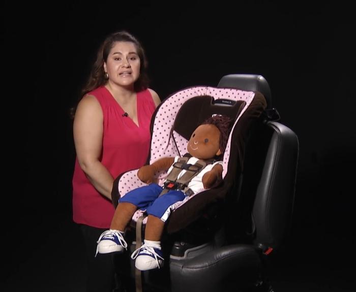Speaker demonstrates proper child seat use