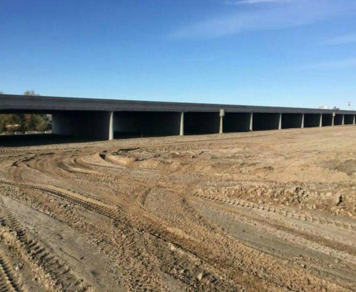 The new Fortuna Wash Bridge spans a dirt construction site under a clear blue sky.