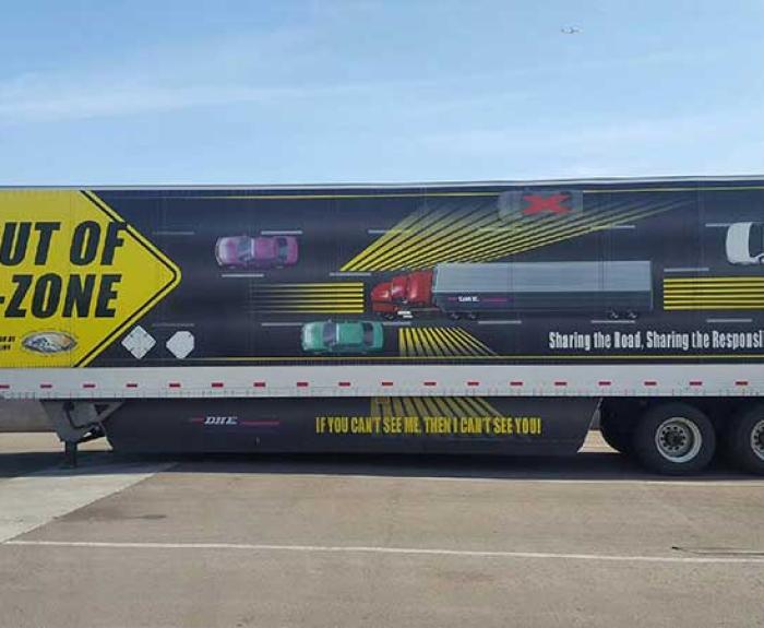 Semi-trailer message warns motorists to avoid trucks' blind spots.