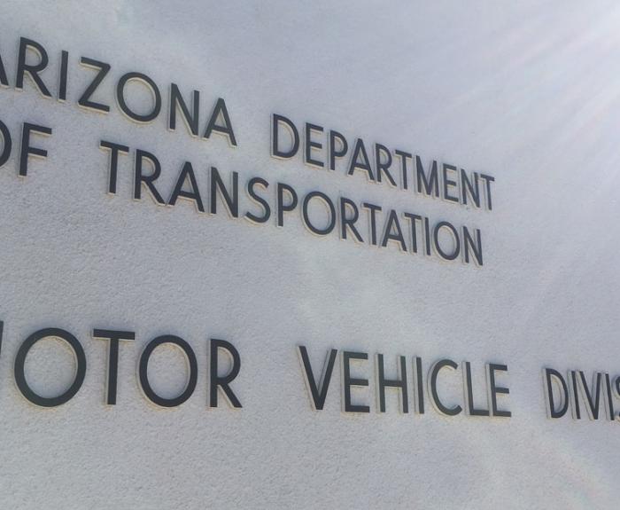 The words Arizona Department of Transportation Motor Vehicle Division are displayed on a light-colored wall.