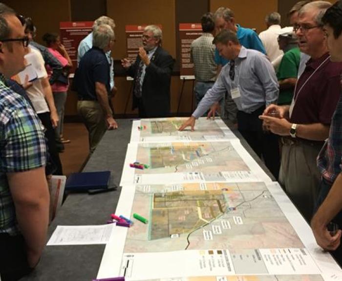 People at public meeting look at tabletop map
