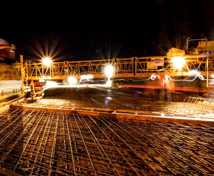Deck pour at night with lights and figure of a person