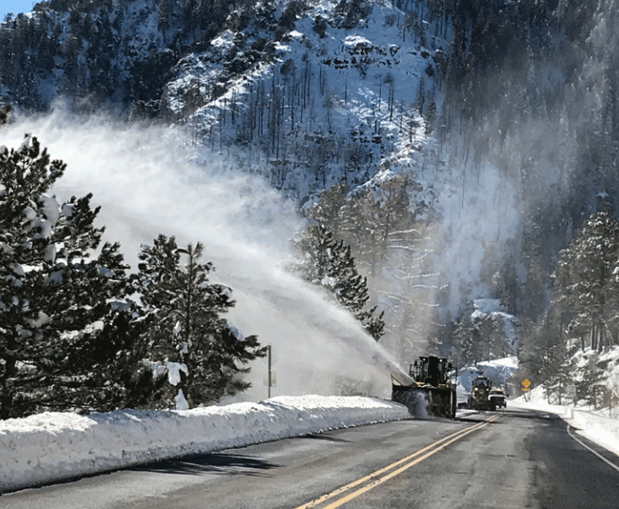 Snow blower at work along highway