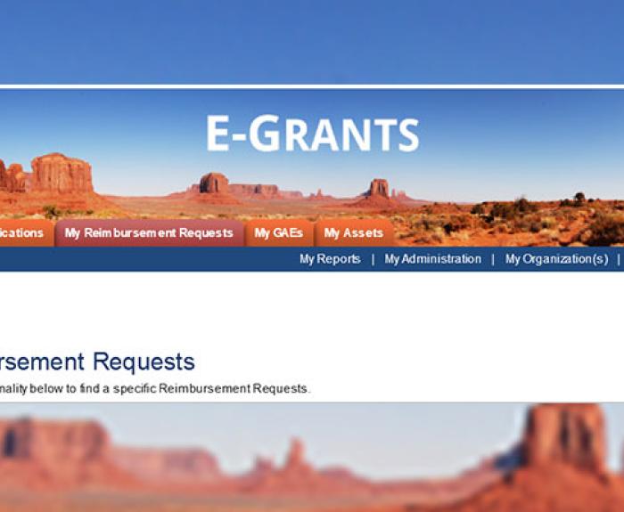 A screenshot of an E-Grants portal with a desert background and navigation menu options displayed.