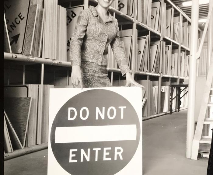 A woman holding a Do Not Enter sign