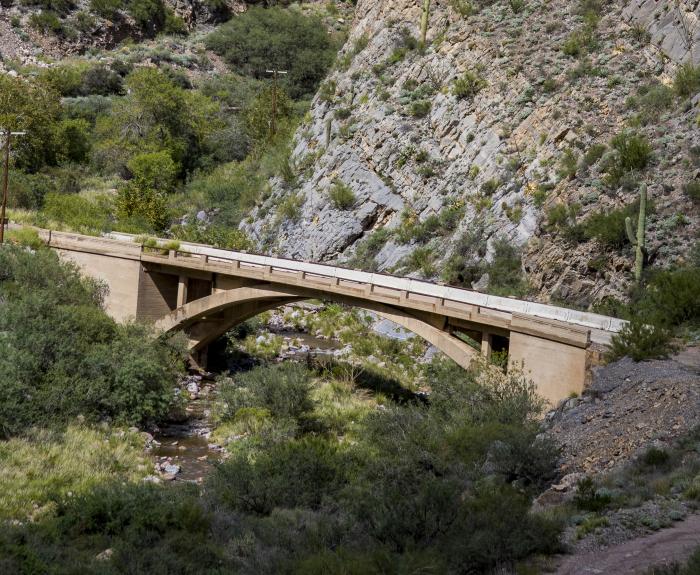 A concrete bridge crosses a rocky canyon