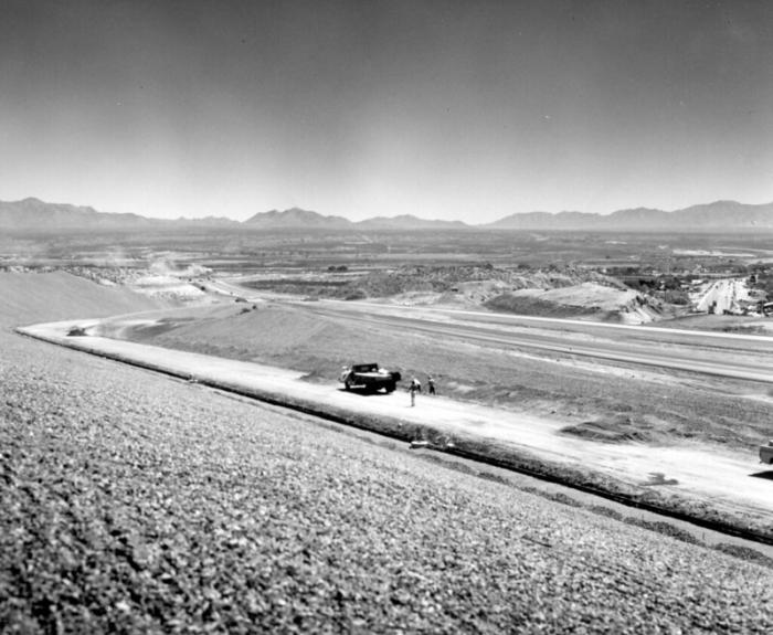 Black and white image of a car on a highway