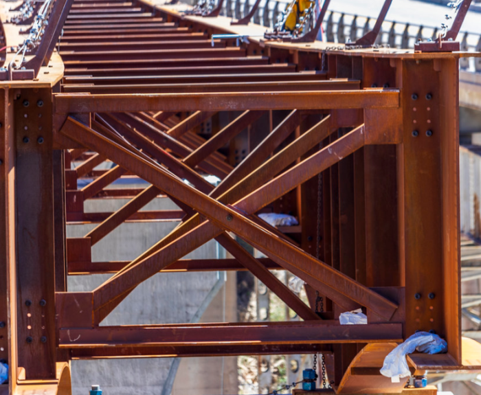 Close-up of a steel bridge under construction showing beams and support structures.