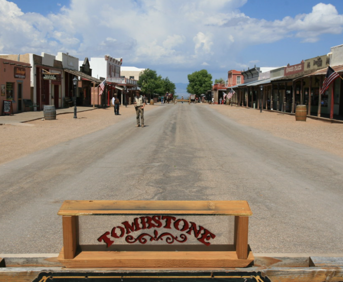 Image of Tombstone sign with the town in the background