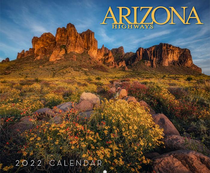 Desert landscape with wildflowers and rocky mountains at sunset, featured on the cover of the Arizona Highways 2022 Calendar.