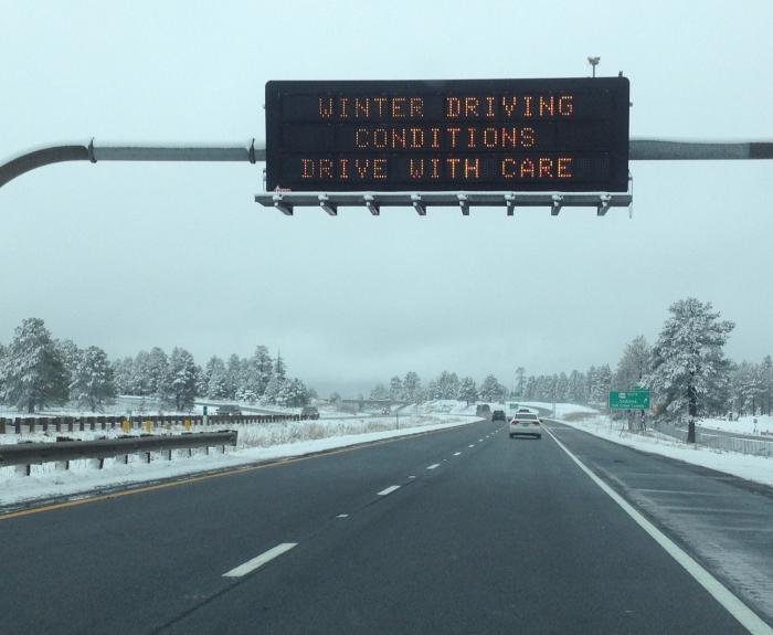 Message board on snowy highway warns of winter conditions
