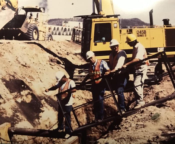 Historic photo of workers viewing trench at project site