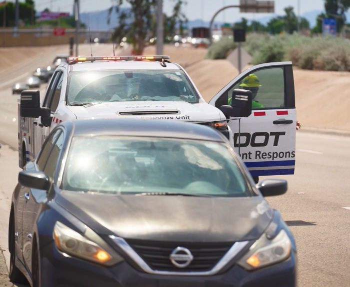 An ADOT truck assisting a stranded motorist on the side of the highway