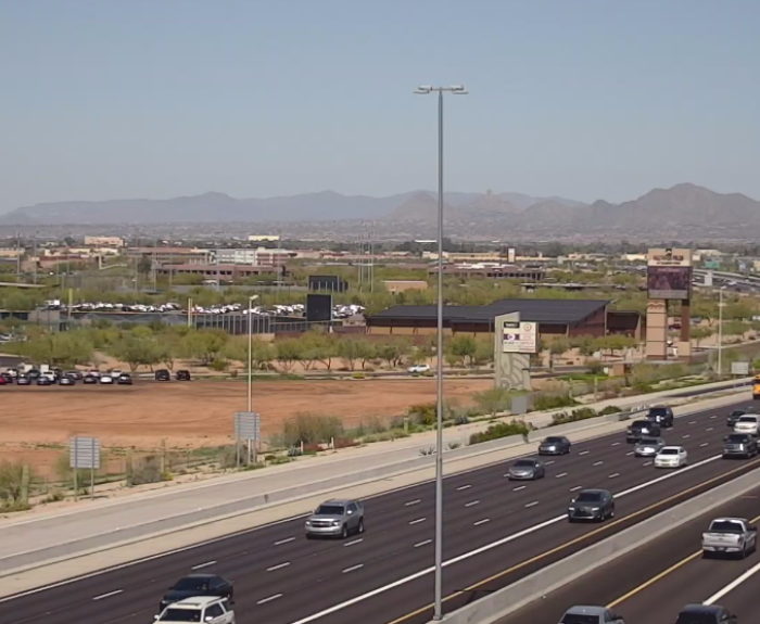 Traffic camera image showing freeway traffic and stadium parking lot