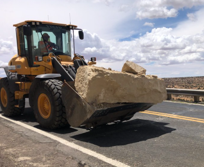 Front loader moves large rock
