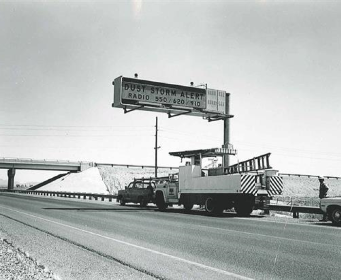 Historic photo showing installation of dust storm alert system sign