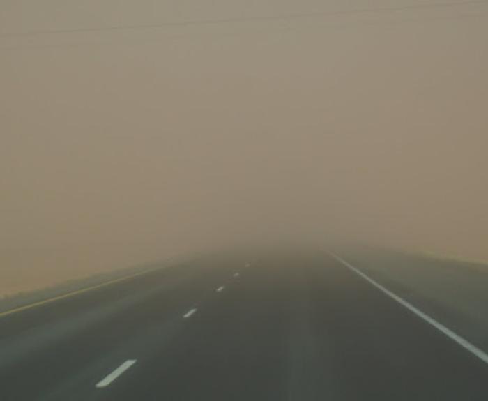 A highway is obscured by dust.