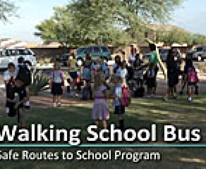 Children and adults walk together in a group outdoors for a Walking School Bus Safe Routes to School Program.